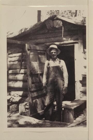 Bert Loper at door of his cabin. Red Canyon in Glen Canyon
