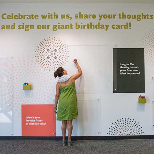 Woman signing The Huntington birthday card