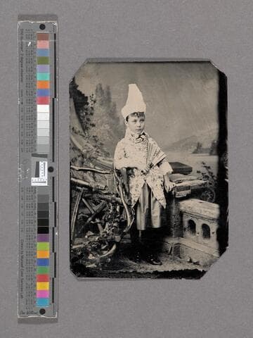 Portrait of unidentified young child holding a paper fan