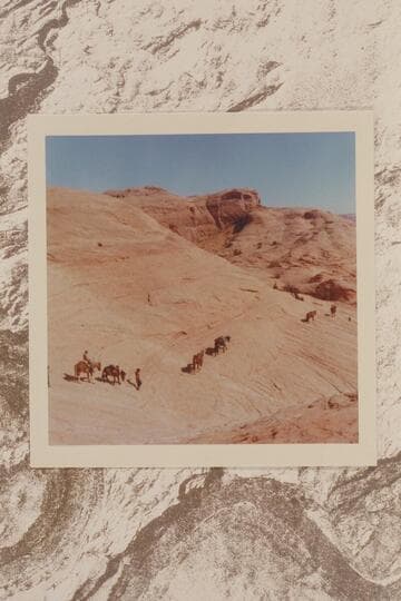Pack string on the slick rock west of Nasja Creek as they swing into the basin of Dead Center Camp