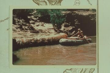 Jorgen Visbak in a small inflated craft at Pumpkin Spring, Mile 212.8 left bank