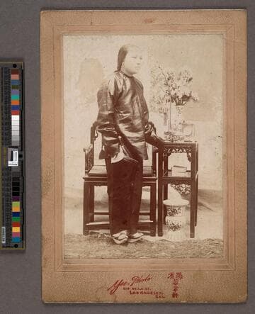 Portrait of a Chinese woman standing next to table and chair