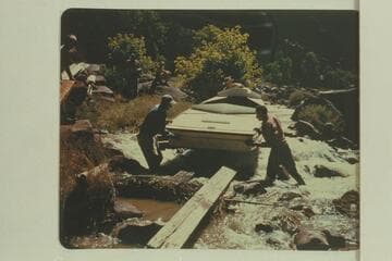 Portage of one of the Wright sadirons at Hells Half Mile. Frank Wright at the bow; Kent Frost at right; Alf Frost at left