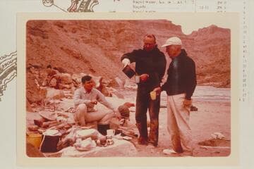 Dock Marston watches for the last drop as Bill Belknap pours the breakfast coffee. Camp at Mile 209.6 RB. Buzz Belknap watches. The lower end of Rapid #6 in the background