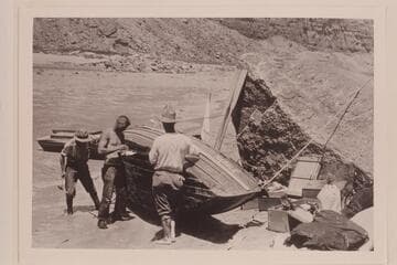 The "Marble" beached for repairs below Badger Creek Rapid. L to R: Kolb, Lint and Moore