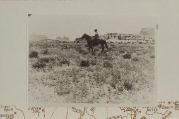 Ned Chaffin on Captain. Water Hole Flat. Sunset Pass and Gunsight Butte in background