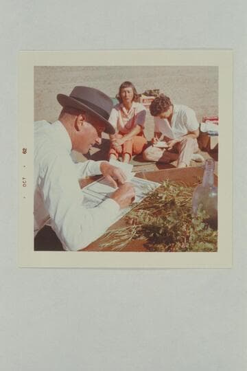 The Flying Bishop Bill Wells makes out the wedding papers while Nina Robison records notes for her news item. For some reason the bride does not look happy. The Chapel, Glen Canyon, Mile 118.5