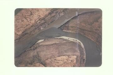 Junction of San Juan and Colorado. Indian trail along left talus. Faint trail on fluvial bench at left center. 8600 cfs. recorded at Lees Ferry
