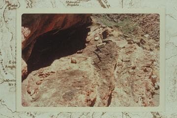The upper story of the "Houserock" at the Bass Mine in Hakatai Canyon. Note the poles inserted into holes in the ledge. This ledge is about half way up the rock