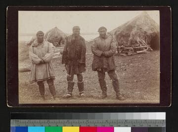 Three Alaska native men outside native houses
