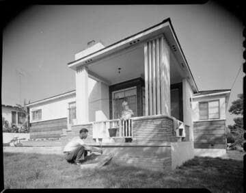 Man laying brick in front of home