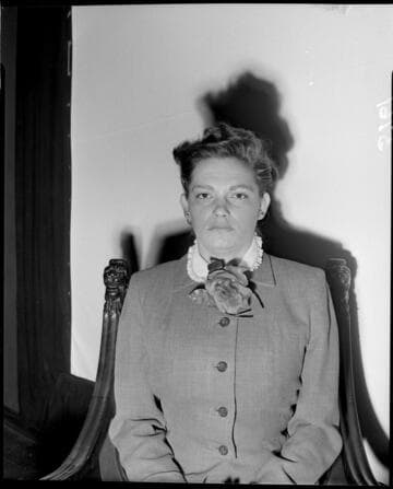 Lady seated in chair against white backdrop