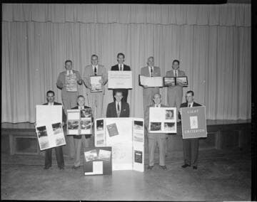 Men in group holding signs and photo cards