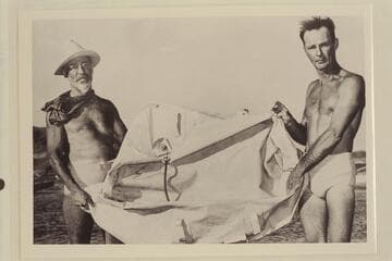 Cropped photo of Dock Marston and Norm Nevills holding the rubber raft found during the 1948 traverse of the Grand Canyon. The raft was found near Mile 220